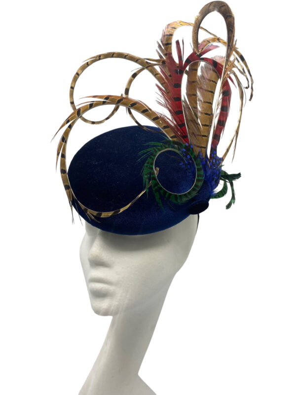 Navy blue velvet based headpiece with an array of coloured feathers.